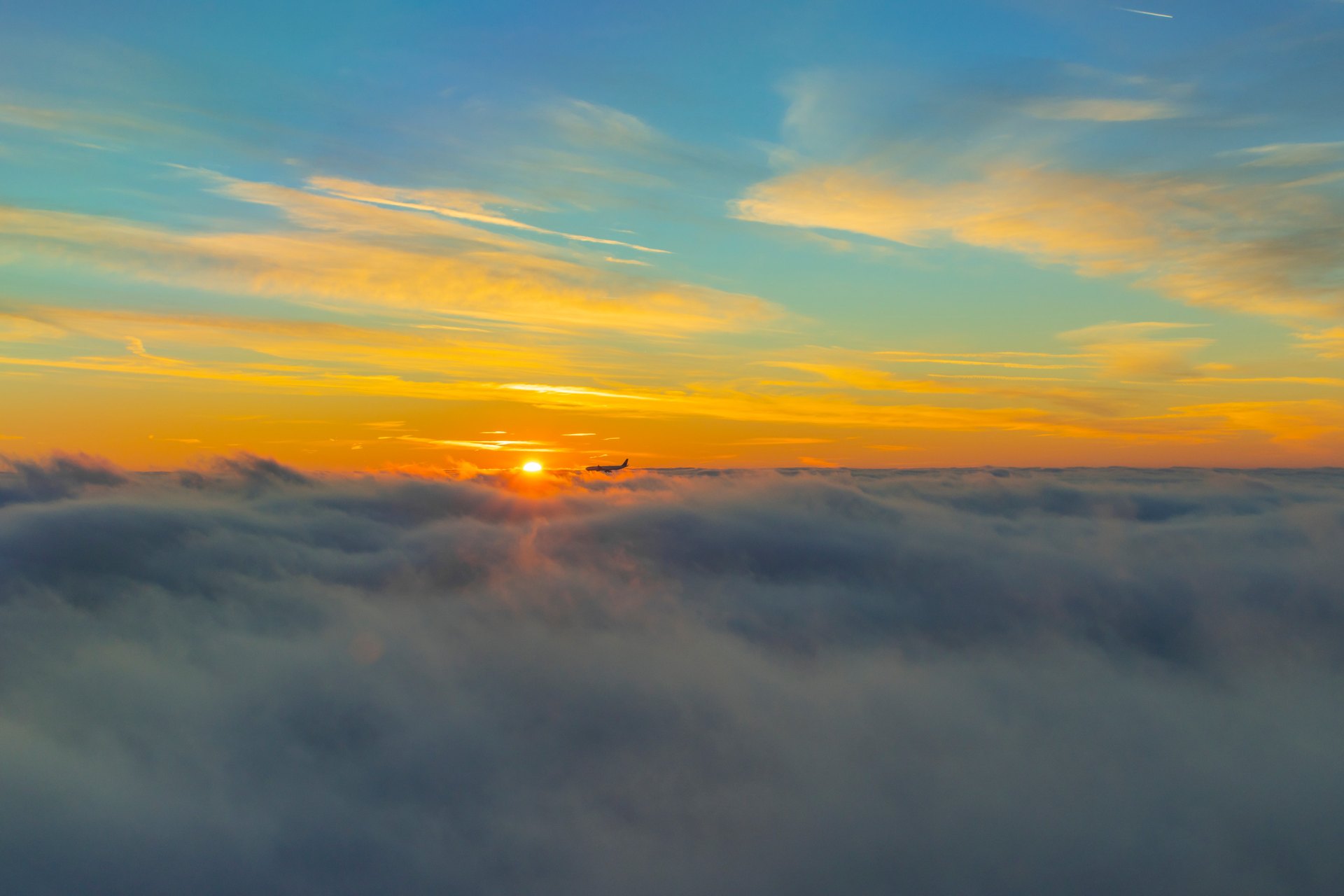 Flugzeug bei Sonnenaufgang über den Wolken