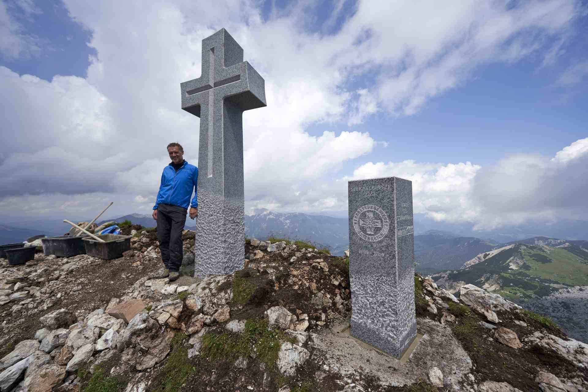 Raimund Walser mit steinernen Gipfelkreuz