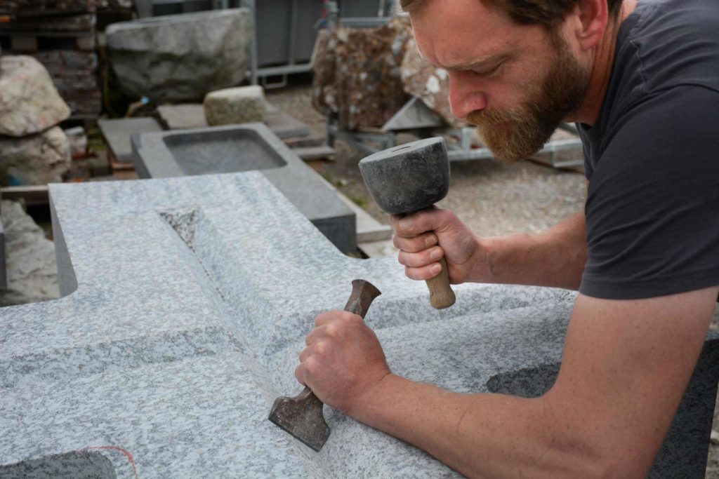 Simon Walser bei der Bearbeitung des Granitblocks