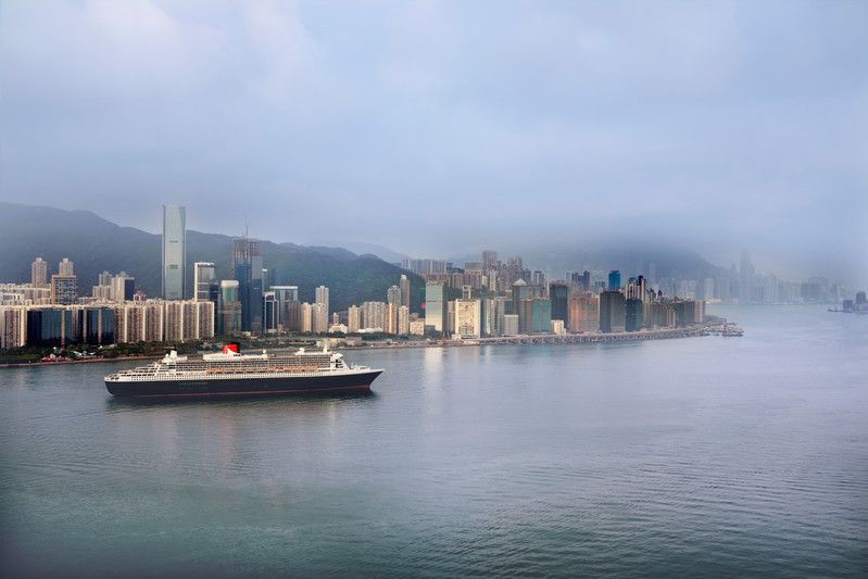 Queen Mary 2 vor der Skyline von Hongkong