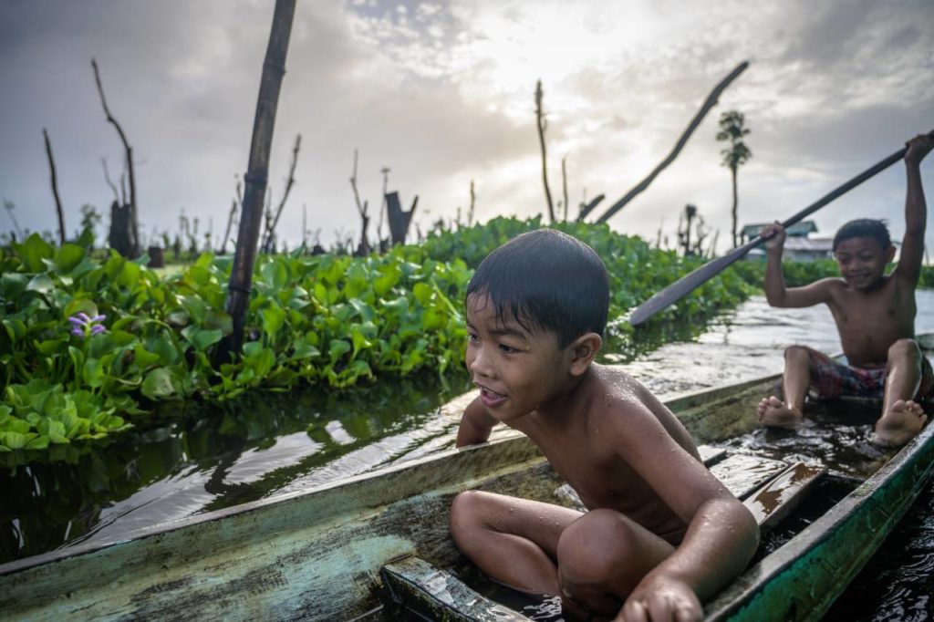 Kinder spielen in einem Boot im Agusan Marsh Wildlife Sanctuary