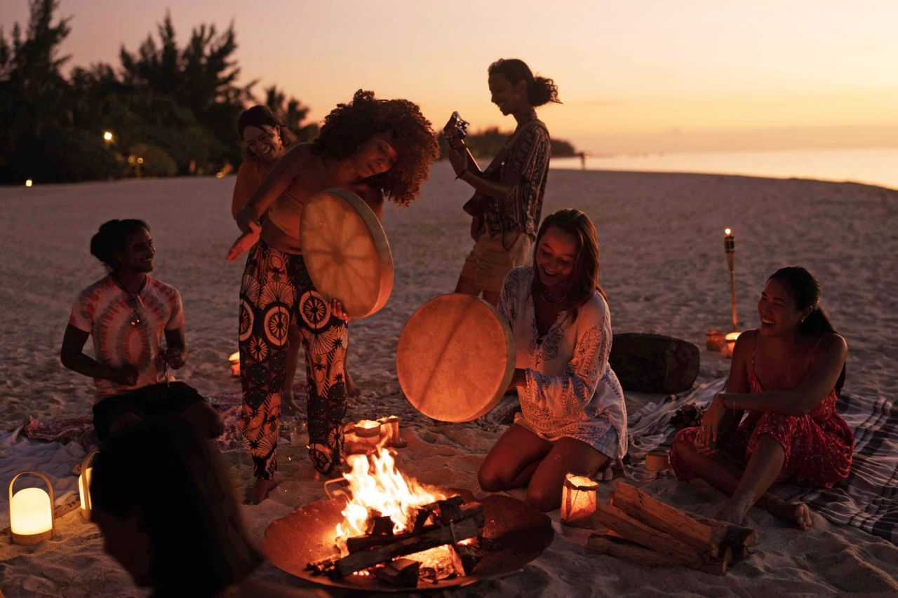 Junge Menschen musizieren am Strand auf Mauritius