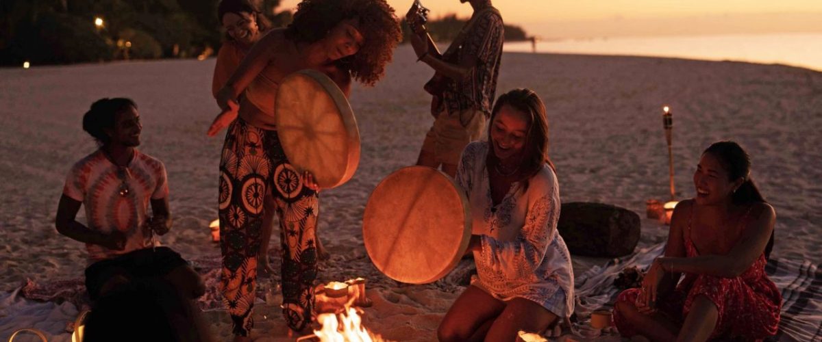 Junge Menschen musizieren am Strand auf Mauritius