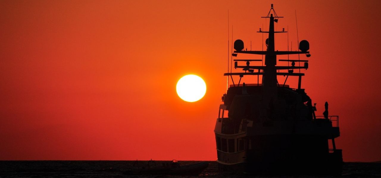 Sonnenuntergang mit Boot-Silhouette vor Mykonos