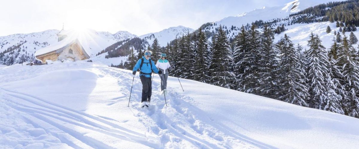 Winterwanderer auf der Schönangeralm mit der Zirbenkapelle